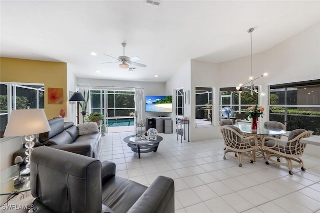 living area with light tile patterned floors, visible vents, recessed lighting, and ceiling fan with notable chandelier
