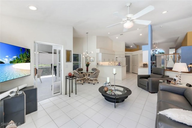 living room with lofted ceiling, light tile patterned floors, and ceiling fan with notable chandelier