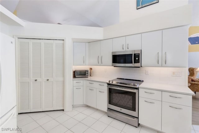 kitchen with a toaster, appliances with stainless steel finishes, light countertops, and decorative backsplash