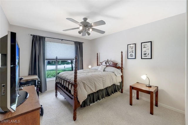 bedroom with light colored carpet, ceiling fan, and baseboards