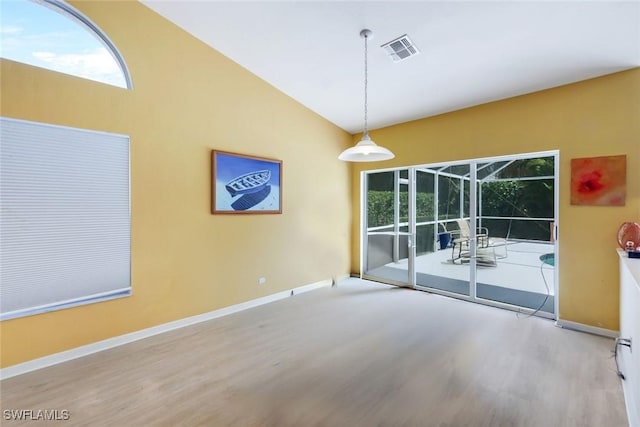 empty room with baseboards, visible vents, and wood finished floors