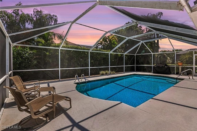 outdoor pool with a patio and glass enclosure