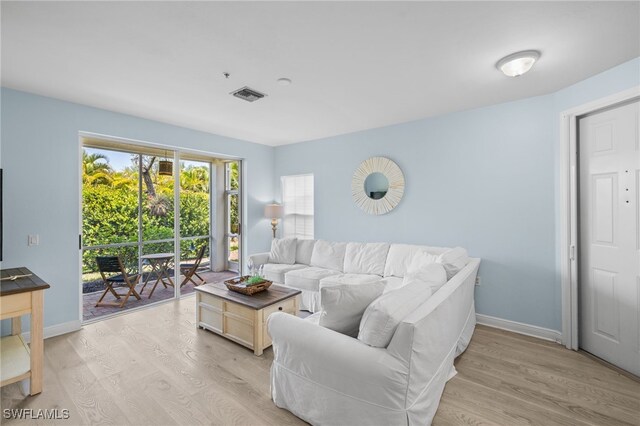 1305 Sweetwater Cv Unit 104, Naples, FL 34110 - living room with visible vents, light wood-type flooring, and baseboards