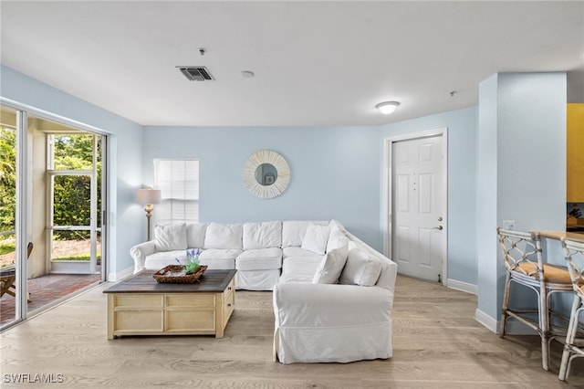 1305 Sweetwater Cv Unit 104, Naples, FL 34110 - living area featuring visible vents, light wood-style flooring, and baseboards