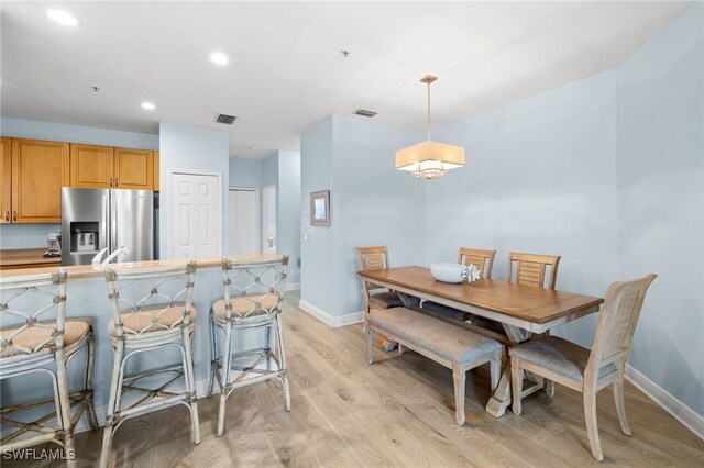 1305 Sweetwater Cv Unit 104, Naples, FL 34110 - interior space featuring stainless steel refrigerator with ice dispenser, light wood-style floors, visible vents, and baseboards