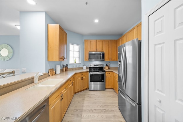 1305 Sweetwater Cv Unit 104, Naples, FL 34110 - kitchen featuring light wood-style flooring, a sink, stainless steel appliances, light countertops, and recessed lighting