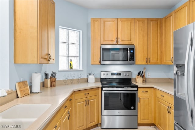 1305 Sweetwater Cv Unit 104, Naples, FL 34110 - kitchen featuring stainless steel appliances, light countertops, and a sink