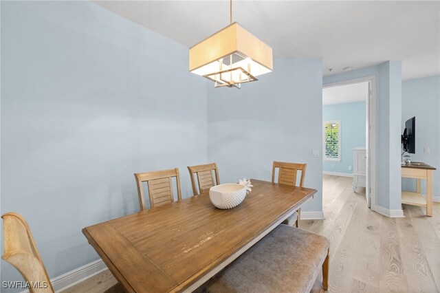 1305 Sweetwater Cv Unit 104, Naples, FL 34110 - dining space with an inviting chandelier, light wood-type flooring, and baseboards