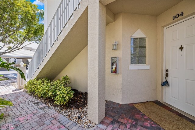 1305 Sweetwater Cv Unit 104, Naples, FL 34110 - entrance to property featuring stucco siding