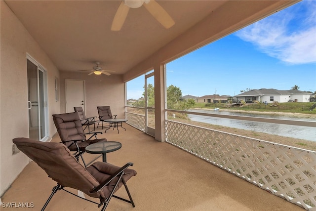 balcony featuring a water view, a ceiling fan, and a residential view