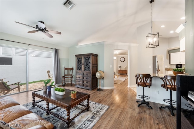 living room featuring visible vents, high vaulted ceiling, light wood-type flooring, and ceiling fan with notable chandelier