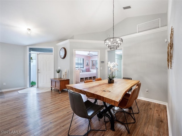 dining space with baseboards, vaulted ceiling, wood finished floors, and plenty of natural light