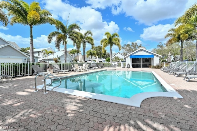 community pool with fence and a patio area