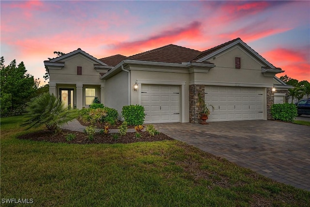 3129 Preserves Edge Ct, Fort Myers, FL 33905 - view of front of house with a front yard, a garage, decorative driveway, a tiled roof, and stucco siding