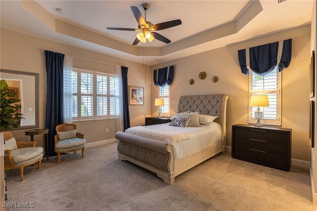 3129 Preserves Edge Ct, Fort Myers, FL 33905 - bedroom featuring light colored carpet, multiple windows, a raised ceiling, and baseboards