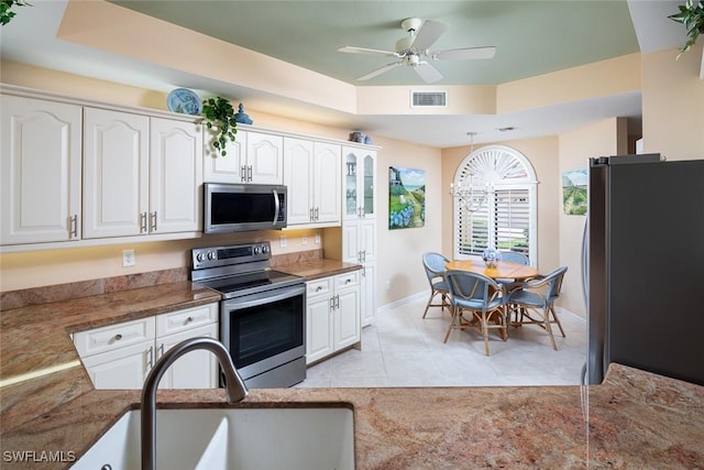 7048 Pelican Bay Blvd Unit C104, Naples, FL 34108 - kitchen with baseboards, white cabinets, a sink, light tile patterned floors, and stainless steel appliances