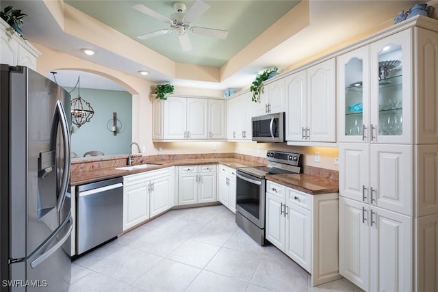 7048 Pelican Bay Blvd Unit C104, Naples, FL 34108 - kitchen featuring appliances with stainless steel finishes, a sink, light tile patterned floors, white cabinets, and ceiling fan with notable chandelier