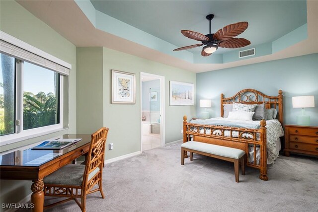 7048 Pelican Bay Blvd Unit C104, Naples, FL 34108 - carpeted bedroom with visible vents, baseboards, a tray ceiling, a ceiling fan, and ensuite bath