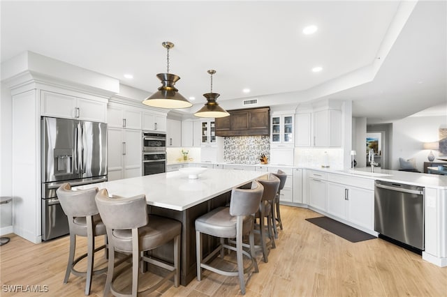 14250 Royal Harbour Ct Unit 913, Fort Myers, FL 33908 - kitchen featuring appliances with stainless steel finishes, a sink, light countertops, glass insert cabinets, and decorative backsplash