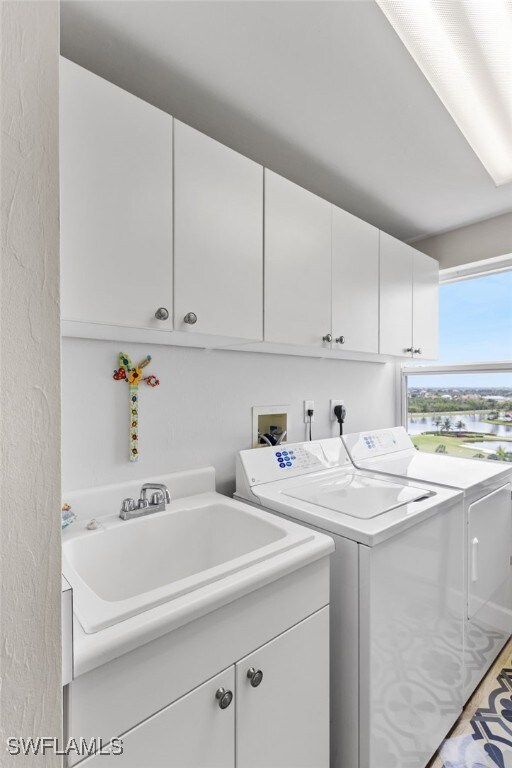 14250 Royal Harbour Ct Unit 913, Fort Myers, FL 33908 - washroom featuring washer and dryer, cabinet space, and a water view