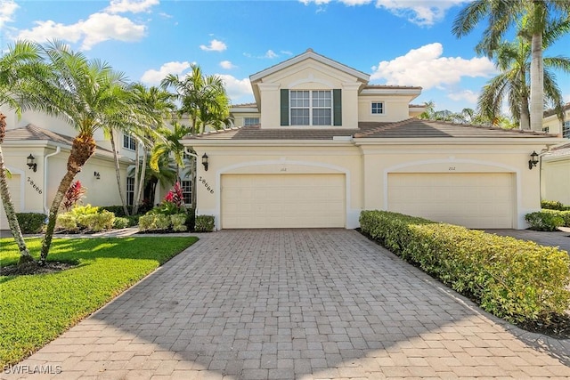 28666 San Lucas Ln Unit 102, Bonita Springs, FL 34135 - view of front facade featuring decorative driveway, a front lawn, stucco siding, and a tiled roof