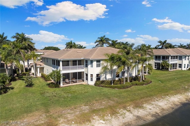 28666 San Lucas Ln Unit 102, Bonita Springs, FL 34135 - back of property featuring a sunroom, a yard, stucco siding, and a tiled roof