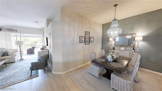 6805 Satinleaf Rd S Unit 201, Naples, FL 34109 - dining space with a notable chandelier, visible vents, light wood-style flooring, baseboards, and lofted ceiling
