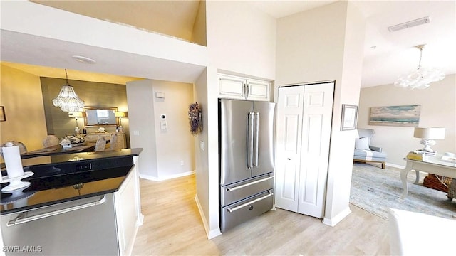 6805 Satinleaf Rd S Unit 201, Naples, FL 34109 - kitchen with an inviting chandelier, high end refrigerator, light wood-style flooring, and white cabinets