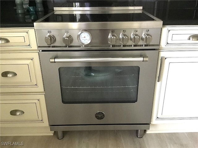 6805 Satinleaf Rd S Unit 201, Naples, FL 34109 - details with wood finished floors, cream cabinets, and high end stainless steel range
