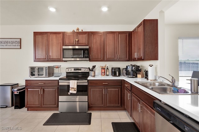 226 NW 4th Ter, Cape Coral, FL 33993 - kitchen featuring a toaster, stainless steel appliances, light tile patterned floors, light countertops, and a sink