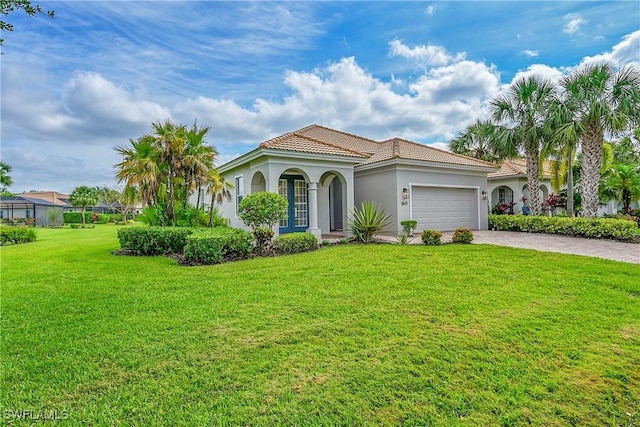 mediterranean / spanish-style house with a tile roof, decorative driveway, an attached garage, stucco siding, and a front lawn