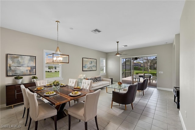 dining space featuring light tile patterned floors, visible vents, baseboards, and ceiling fan with notable chandelier