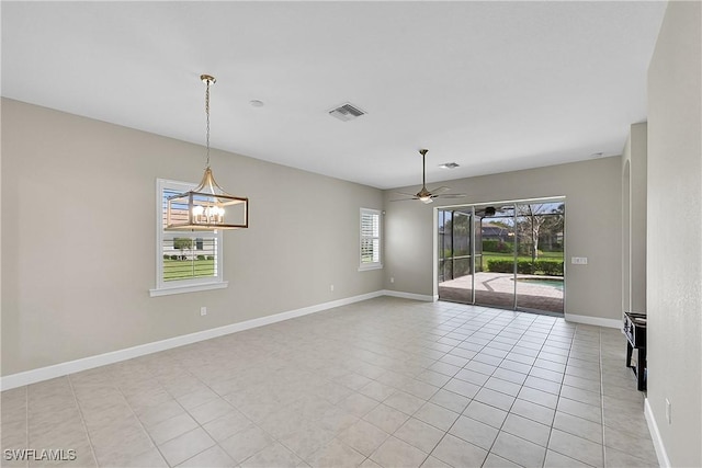 spare room with light tile patterned floors, ceiling fan with notable chandelier, visible vents, and baseboards
