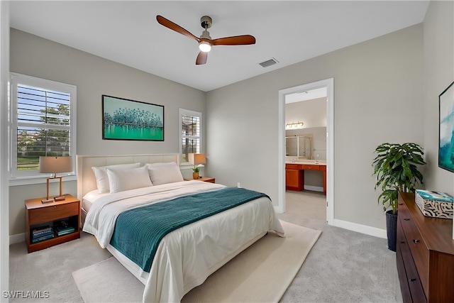bedroom with connected bathroom, ceiling fan, visible vents, baseboards, and light carpet