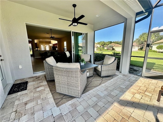 sunroom / solarium featuring a ceiling fan and plenty of natural light