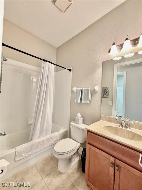 full bath featuring shower / bath combo, vanity, tile patterned floors, toilet, and visible vents