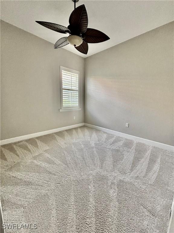 unfurnished room with baseboards, a ceiling fan, and carpet flooring