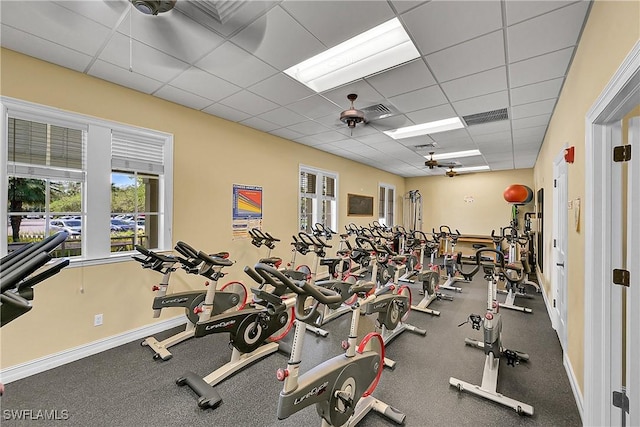 gym featuring visible vents, a drop ceiling, and baseboards