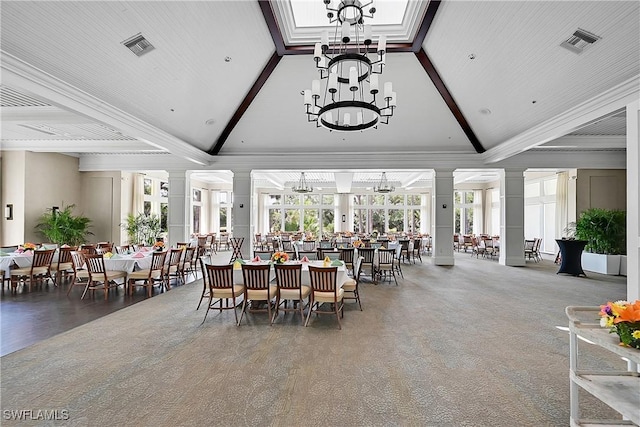 carpeted dining area featuring an inviting chandelier, beam ceiling, high vaulted ceiling, visible vents, and ornate columns