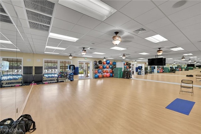exercise room featuring wood finished floors, visible vents, and a drop ceiling
