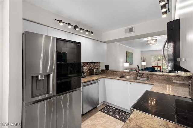 kitchen featuring tasteful backsplash, appliances with stainless steel finishes, a sink, white cabinetry, and visible vents