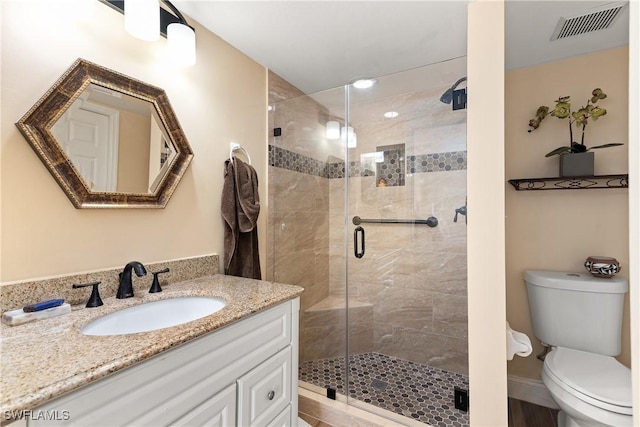 bathroom with visible vents, a stall shower, toilet, and vanity