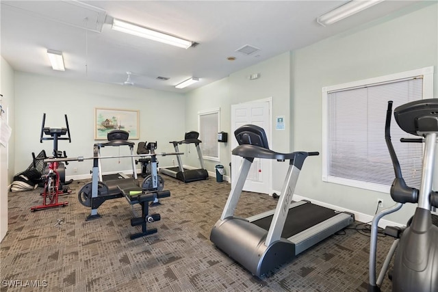 exercise room with attic access, visible vents, carpet, and baseboards
