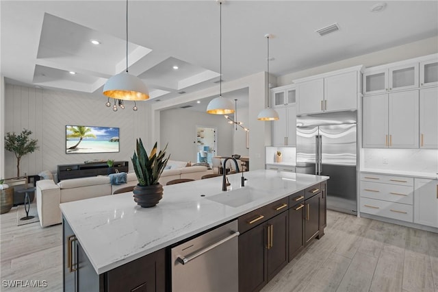 16198 Verilyn Cir, Naples, FL 34110 - kitchen featuring stainless steel appliances, a sink, open floor plan, white cabinets, and light wood-type flooring