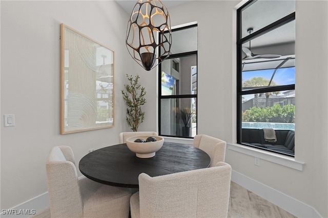 16198 Verilyn Cir, Naples, FL 34110 - dining area with baseboards, a chandelier, and wood finished floors