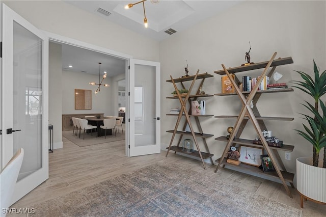16198 Verilyn Cir, Naples, FL 34110 - spare room featuring french doors, wood finished floors, a chandelier, and baseboards