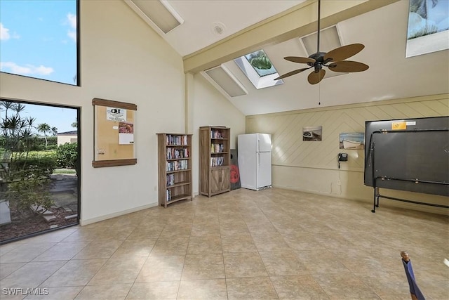 4719 SE 17th Pl Unit 208, Cape Coral, FL 33904 - interior space with wood walls, light tile patterned flooring, high vaulted ceiling, a ceiling fan, and a skylight