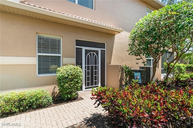 view of exterior entry featuring stucco siding