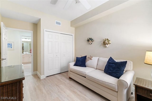 living area with light wood-style floors, a ceiling fan, and visible vents