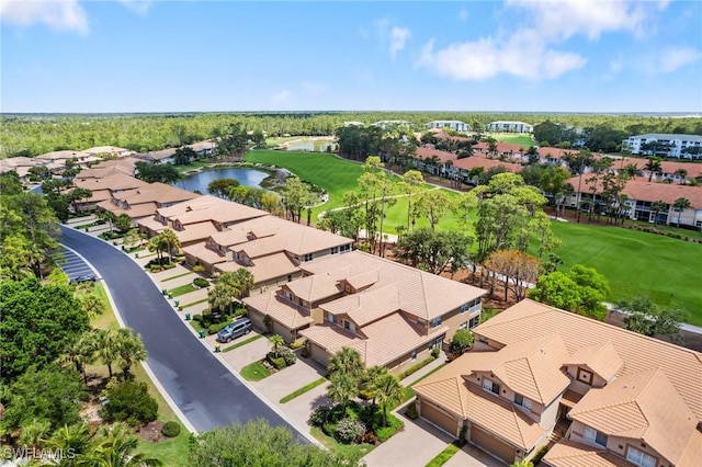 drone / aerial view featuring a residential view, view of golf course, and a water view